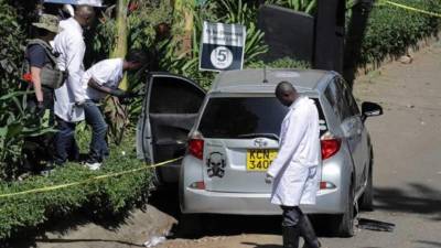 Agentes de policía y expertos forenses permanecen junto a un vehículo sospechoso de haber sido utilizado por presuntos terroristas para el ataque yihadista a un complejo hotelero el pasado martes, en Nairobi, Kenia. EFE