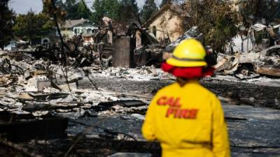 SANTA ROSA, CA - OCTOBER 13: A Cal Fire employee surveys damage in the Coffey Park neighborhood caused by the Tubbs Fire on Oct. 13, 2017 in Santa Rosa, California. Twenty four people have died in wildfires that have burned tens of thousands of acres and destroyed over 3,500 homes and businesses in several Northern California counties. Elijah Nouvelage/Getty Images/AFP