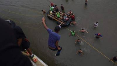 En la imagen de archivo, migrantes hondureños de la primera caravana se lanzan al río Suchiate en la frontera de México y Guatemala. EFE