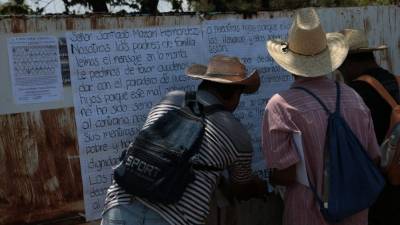 Padres de los normalistas desaparecidos cuelgan un cartel para comunicarse con el líder del cartel Los Rojos.