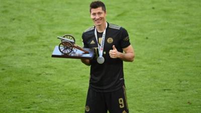 Bayern Munich's Polish forward Robert Lewandowski poses with the trophy for the leading goal scorer of the Bundesliga 2020 - 2021 season after the German first division Bundesliga football match Bayern Munich vs FC Augsburg in Munich, southern Germany, on May 22, 2021. (Photo by Sven Hoppe / POOL / AFP) / DFL REGULATIONS PROHIBIT ANY USE OF PHOTOGRAPHS AS IMAGE SEQUENCES AND/OR QUASI-VIDEO