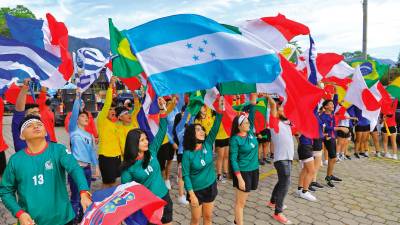 Alzando sus banderas, los jóvenes disfrutaron previo al desfile.