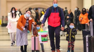 Commuters wearing face masks walk in Hankou railway station in Wuhan, in China's central Hubei province on January 21, 2020. - Asian countries on January 21 ramped up measures to block the spread of a new virus as the death toll in China rose to six and the number of cases surpassed 300, raising concerns in the middle of a major holiday travel rush. (Photo by - / AFP) / China OUT