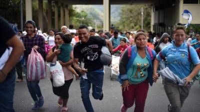 Migrantes hondureños corrieron después de pasar la aduana de Agua Caliente entre Honduras y Guatemala. Autoridades guatemaltecas contabilizaron a más de 1,000 hondureños que presentaron sus documentos para ingresar de forma legal al país.