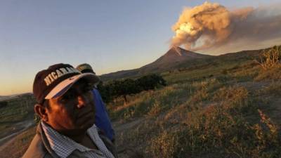 Gente observa el volcán Momotombo haciendo erupción en la comunidad de Papalonal del municipio de La Paz Centro, Leon, Nicaragua. Foto AFP.