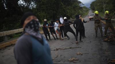 <i>Personas de la comunidad Piriati Embera ayudan a integrantes del Servicio Nacional de Fronteras a retirar unos cables eléctricos este jueves en Piriati (Panamá). EFE/ Bienvenido Velasco</i>
