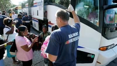 Beaumont Fire and Rescue authorities assist evacuees onto waiting busses as they prepare to depart for destinations throughout Texas due to the impending landfall of hurricane Ike, Thursday, Sept. 11, 2008, in Beaumont, Texas. (AP Photo/Tony Gutierrez)