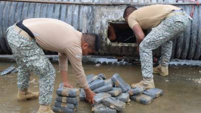 Fotografía cedida por la Armada Nacional, que muestra la inspección de una embarcación en la que se ha hallado un cargamento de marihuana en el río Putumayo, en Puerto Leguízamo, departamento del Putumayo.