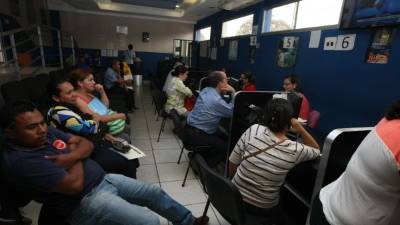 Decenas de usuarios de la Enee aguardan su turno en la oficina de atención al cliente.