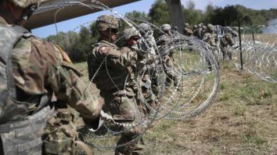 HIDALGO, TX - NOVEMBER 02: U.S. Army soldiers from Ft. Riley, Kansas install protective wire along the Rio Grande at the U.S.-Mexico border on November 2, 2018 in Hidalgo, Texas. U.S. President Donald Trump ordered the troops to the border to bolster security at points of entry where an immigrant caravan may attempt to cross in upcoming weeks. The troops in Hidalgo were from the 97th MP Battalion and had arrived to the Rio Grande Valley the day before. John Moore/Getty Images/AFP