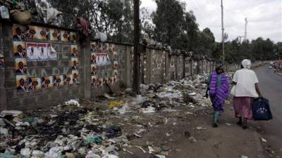 Dos mujeres caminan por una calle llena de basura en Kibera, el suburbio más poblado de África, situado en Nairobi (Kenia). EFE/Archivo