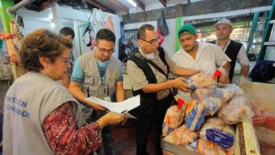 Inspectores de la Secretaría de Desarrollo Económico y de la Región Metropolitana haciendo las inspecciones en uno de los puestos del mercado Dandy . Foto: Wendell Escoto.