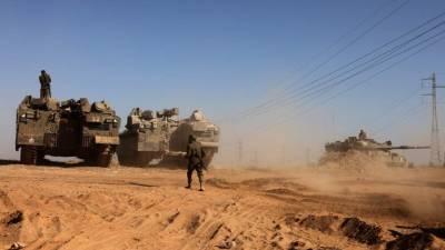 Israeli troops are pictured from their position in southern Israel along the border with the Gaza Strip on May 14, 2021. - Israel pounded Gaza and deployed extra troops to the border as Palestinians fired barrages of rockets back, with the death toll in the enclave on the fourth day of conflict climbing to over 100. (Photo by Menahem KAHANA / AFP)