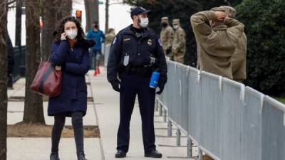 Un oficial de policía habla con soldados de la Guardia Nacional en el Capitolio de EEUU en Washington D.C. Foto EFE