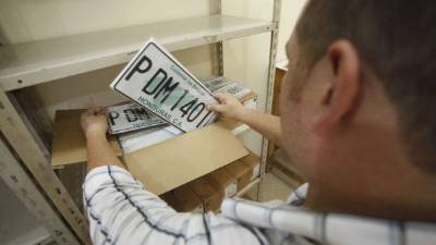 En las bodegas del IP un empleado revisa una caja con las placas que se entregarán.