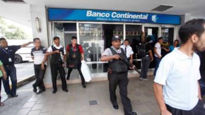 Foto de archivo registra cuando empleados de empresa de valores retiraban dinero de Banco Continental.