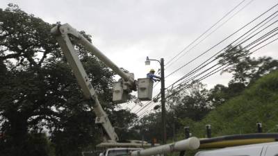 Cuadrilla de la Enee coloca una luminaria.