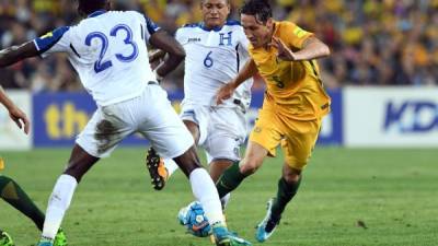 Australia's Mark Milligan is tackled by Honduras' Brayan Acosta (C) and Johnny Palacois (L) during their 2018 World Cup qualification play-off football match against at Stadium Australia in Sydney on November 15, 2017. / AFP PHOTO / William WEST / -- IMAGE RESTRICTED TO EDITORIAL USE - STRICTLY NO COMMERCIAL USE --