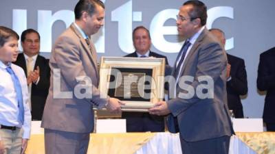 Momento en el que el periodista Elán Reyes (lado izquierdo) recibe el premio de manos del presidente del CPH, Dagoberto Rodríguez.