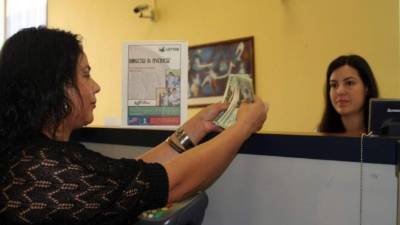 Una mujer reclama su remesa en un banco mexicano.