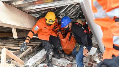 Rescatistas continúan sacando cuerpos de entre los escombros de varios edificios derribados tras el sismo.