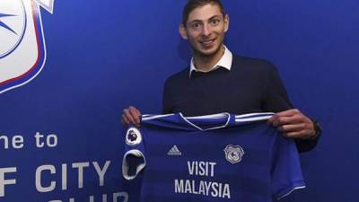 Picture released by Cardiff City FC via Noticias Argentinas, showing Argentine footballer Emiliano Sala posing with Cardiff's jersey after signing for the club, in Cardiff, on January 20, 2019. - Premier League club Cardiff City's record new signing, Argentine striker Emiliano Sala, is missing presumed dead after a light aircraft he was travelling in disappeared over the English Channel on January 21, 2019. Police on the British island of Guernsey have suspended their search for the evening on January 22. Sala was heading to the Welsh capital after saying his final goodbyes to former teammates at French Ligue 1 Nantes. (Photo by HO / NOTICIAS ARGENTINAS / AFP) / - Argentina OUT / RESTRICTED TO EDITORIAL USE - MANDATORY CREDIT 'AFP PHOTO / CCFC / NA' - NO MARKETING NO ADVERTISING CAMPAIGNS - DISTRIBUTED AS A SERVICE TO CLIENTS