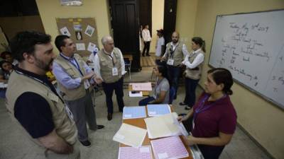 El líder de la misión de observadores de la ONU, Andrés Pastrana (c), junto a otros observadores, revisan la cuenta de votos . EFE