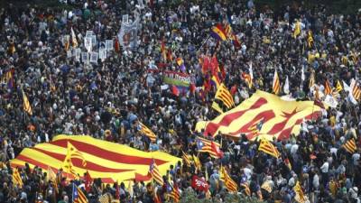 Varias personas portan banderas republicanas durante la concentración que ha tenido lugar en la Puerta del Sol de Madrid después de conocerse la abdicación del Rey en favor del príncipe Felipe.