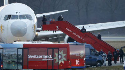 Varios policías ayudan a los pasajeros tras finalizar el secuestro de un avión de Ethiopian Airlines en el aeropuerto de Ginebra (Suiza).