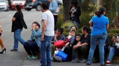 Varias personas esperan nerviosamente en una calle de la Ciudad de México tras el fuerte sismo del viernes.