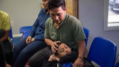 En esta foto de archivo tomada el 17 de junio de 2018, un inmigrante de El Salvador y su hijo de 10 años en un centro de socorro de Caridades Católicas en McAllen, Texas.