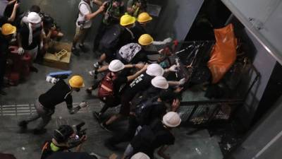Manifestantes enmascarados irrumpieron en los recintos tras abrirse paso en el edificio rompiendo ventanas de vidrio y derribando puertas./AFP.