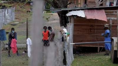 Migrantes hablan con un agente del Servicio Nacional de Fronteras de Panamá. Foto: EFE