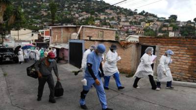 Personnel of the Health Secretary visit different sectors on the northern outskirts of Tegucigalpa during a campaign to fight dengue fever amid the COVID-19 novel coronavirus pandemic, on August 28, 2020, after people were found to be infected with both diseases. - The pandemic has killed at least 832,336 people worldwide, including more than 1,800 in Honduras, since surfacing in China late last year, according to a tally from official sources compiled by AFP at 1100 GMT on Friday. (Photo by Orlando SIERRA / AFP)