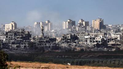 Una fotografía tomada desde Sderot, a lo largo de la frontera con la Franja de Gaza, muestra humo elevándose detrás de edificios destruidos en el enclave palestino durante un ataque israelí, en medio de las batallas en curso entre Israel y el movimiento palestino Hamas, el 10 de noviembre de 2023.