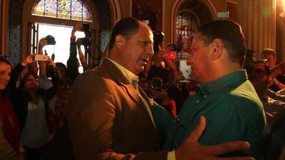 El candidato del Partido Liberación Nacional, Johnny Araya (d) saluda a Luis Guillermo Solis (i), candidato del Partido Acción Ciudadana hoy, domingo 2 de febrero de 2014, durante una misa en San José (Costa Rica). Los costarricenses eligen al sustituto de la primera mujer que ha presidido el país, Laura Chinchilla, tras una campaña que presagia la necesidad de una segunda vuelta en las urnas. EFE/STR