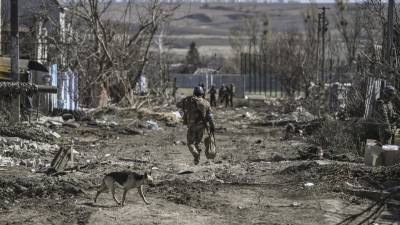 Tropas ucranianas patrullan una ciudad devastada por los bombardeos rusos.