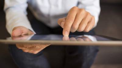 Un hombre navega por Internet en una tableta.