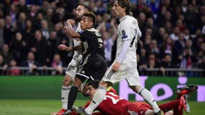 Ajax's Brazilian forward David Neres (C) eyes the ball after scoring against Real Madrid's Belgian goalkeeper Thibaut Courtois during the UEFA Champions League round of 16 second leg football match between Real Madrid CF and Ajax at the Santiago Bernabeu stadium in Madrid on March 5, 2019. (Photo by JAVIER SORIANO / AFP)