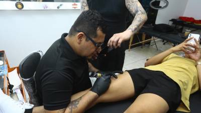 Mario Castro, uno de los coordinadores del evento realiza un tatuaje a un joven.