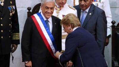 El nuevo presidente Sebastián Piñera al momento en que recibe la banda de parte de la expresidente Michelle Bachelet.