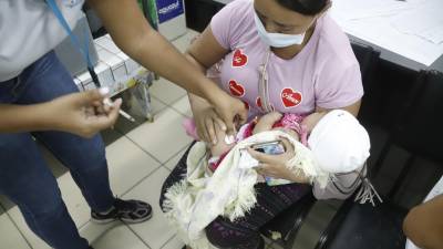 Una madre lleva a su bebé a vacunar al centro de salud Miguel Paz Barahona.