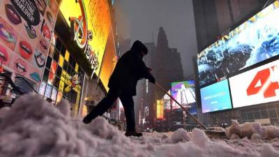 Un hombre camina sobre la nieve en una calle en el Times Square en Nueva York el 14 de marzo de 2017. AFP