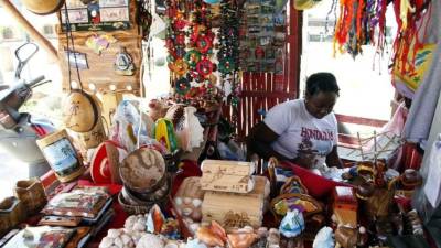 Una mujer atiende su puesto de artesanías.