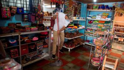 Un trabajador limpia el piso en una tienda de artesanías en Valle de Ángeles. Foto: EFE