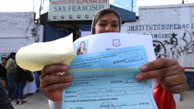 Esta madre muestra el pago que hizo para matricular a su hijo.