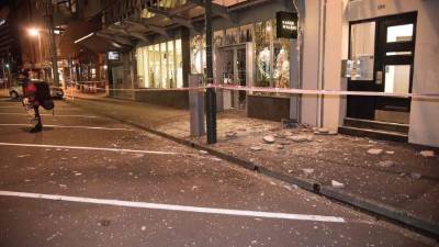 Debris from fallen concrete off buildings are seen on a sidewalk past a cordon line in Wellington early on November 14, 2016 following an earthquake centred some 90 kilometres (57 miles) north of New Zealand's South Island city of Christchurch. A powerful 7.8 magnitude earthquake rocked New Zealand early November 14, the US Geological Survey said, prompting a tsunami warning and knocking out power and phone services in many parts of the country. / AFP PHOTO / Marty Melville