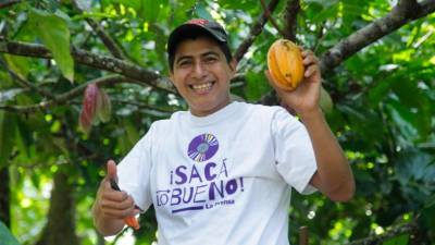 David Iriarte muestra orgulloso una mazorca de cacao recién cortada en una plantación ubicada en una aldea de Omoa. Foto: Wendell Escoto