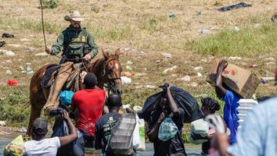 A United States Border Patrol agent on horseback uses the reins as he tries to stop Haitian migrants from entering an encampment on the banks of the Rio Grande near the Acuna Del Rio International Bridge in Del Rio, Texas on September 19, 2021. - The United States said Saturday it would ramp up deportation flights for thousands of migrants who flooded into the Texas border city of Del Rio, as authorities scramble to alleviate a burgeoning crisis for President Joe Biden's administration. (Photo by PAUL RATJE / AFP)