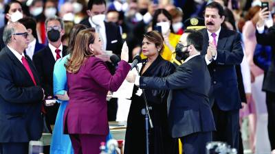 El expresidente Manuel Zelaya Rosales mostró ayer la banda presidencial que él recibió cuando asumió el poder en 2006 y exhibió seguidamente la nueva banda, con franjas azul turquesa, con la cual invistieron a la presidenta que rindió la promesa de ley ante una jueza.